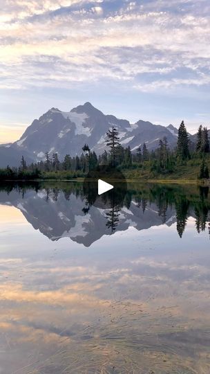 a lake with trees and mountains in the background