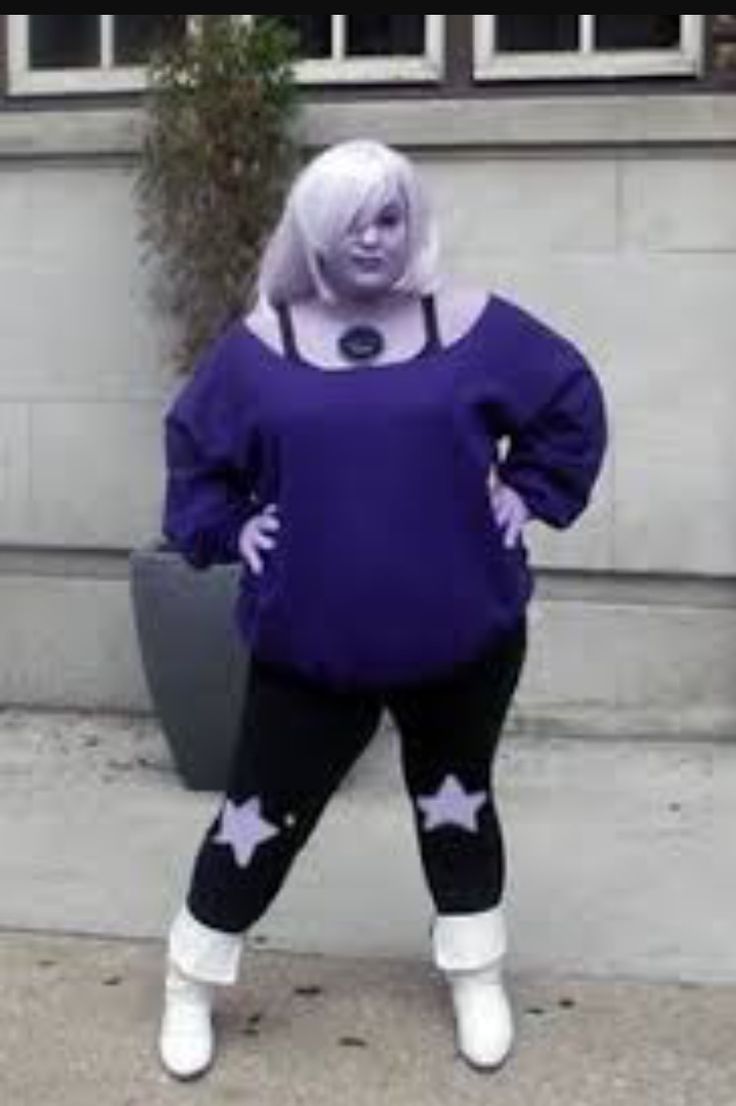 a woman in purple is standing on the sidewalk