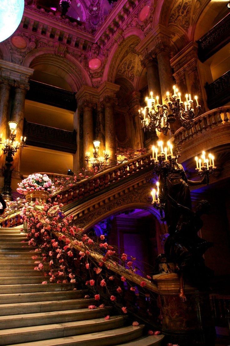 an ornate staircase with flowers and chandeliers