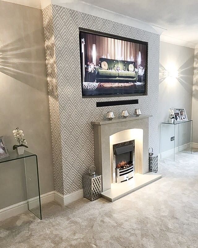 a living room filled with furniture and a flat screen tv mounted on the wall above a fire place