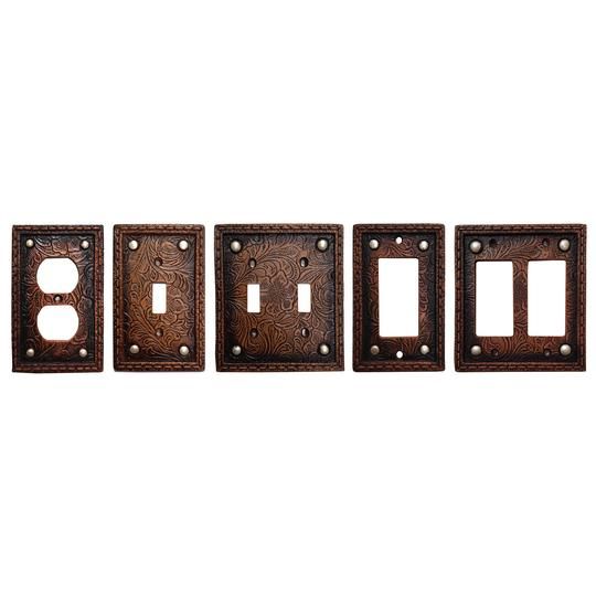 three switchplates and one outlet cover are shown in antique brass finish with ornate designs