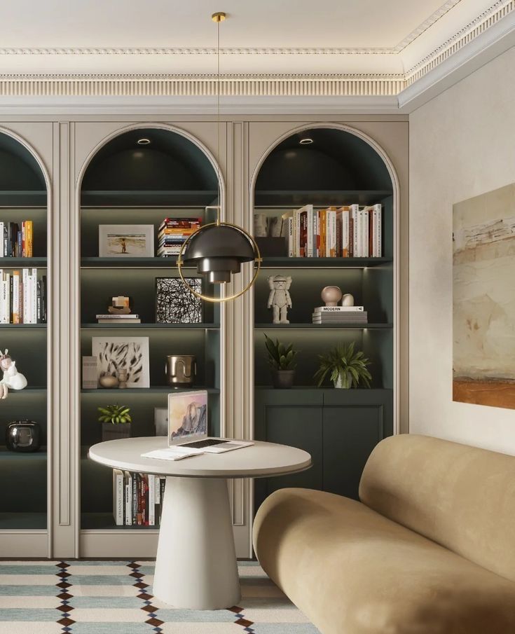 a living room filled with furniture and bookshelves next to a table in front of a book case