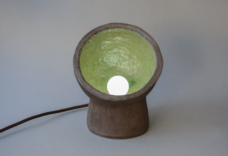 a lamp that is on top of a wooden stand with a white light in the middle