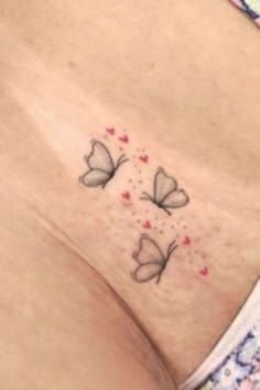 a woman's stomach with two butterflies on it and hearts in the bottom half