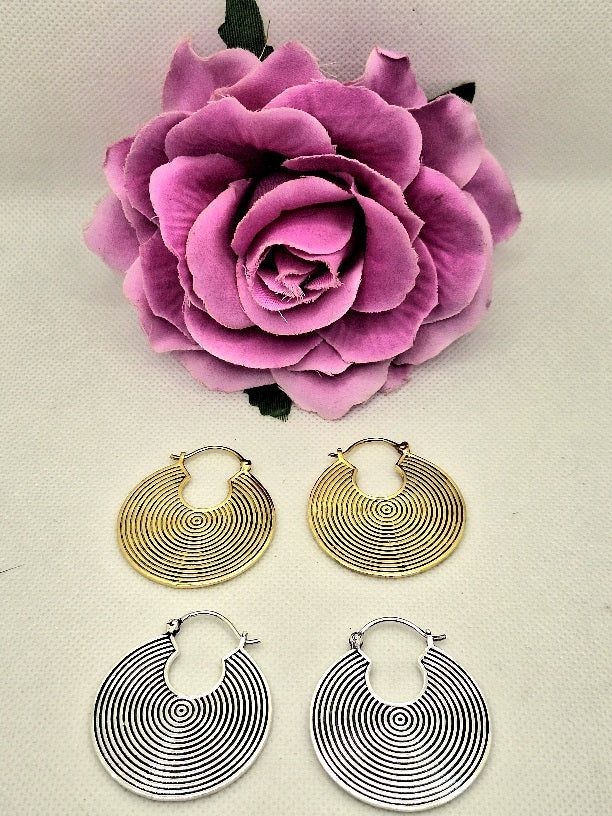 Earrings with concentric circles in silver bath. Small round notch on top. Snap closure.Diameter: 3.8cmWeight: 8 g each100% nickel-free and hypoallergenic silver bath.Buy them together with the matching pendant.Carefully crafted by artisans from Rajasthan, North India. Round Festival Earrings, Round Metal Plug Earrings For Festival, Metal Round Plug Earrings For Festival, Circular Silver Brass Jewelry, Silver Round Brass Hoop Earrings, Silver Brass Round Disc Jewelry, Silver Hoop Plug Earrings In Brass, Silver Circle Brass Earrings, Nickel-free Metal Plug Earrings