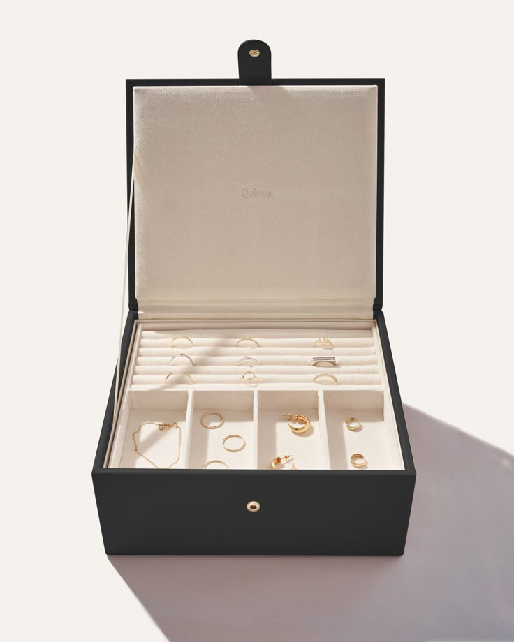 an open box with several rings in it on a white surface and one is empty