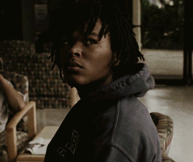 a man with dreadlocks sitting in a living room