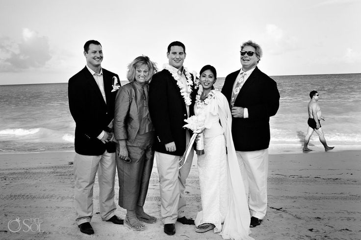 a group of people standing next to each other on a beach