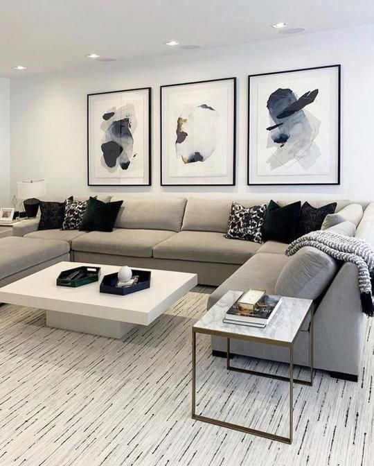 a living room filled with furniture and pictures on the wall above it's coffee table