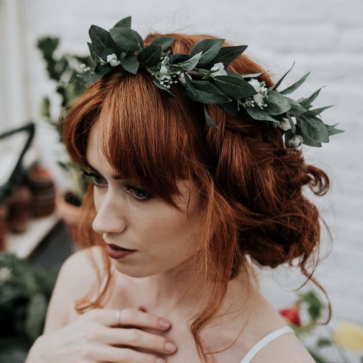 a woman with red hair wearing a flower crown