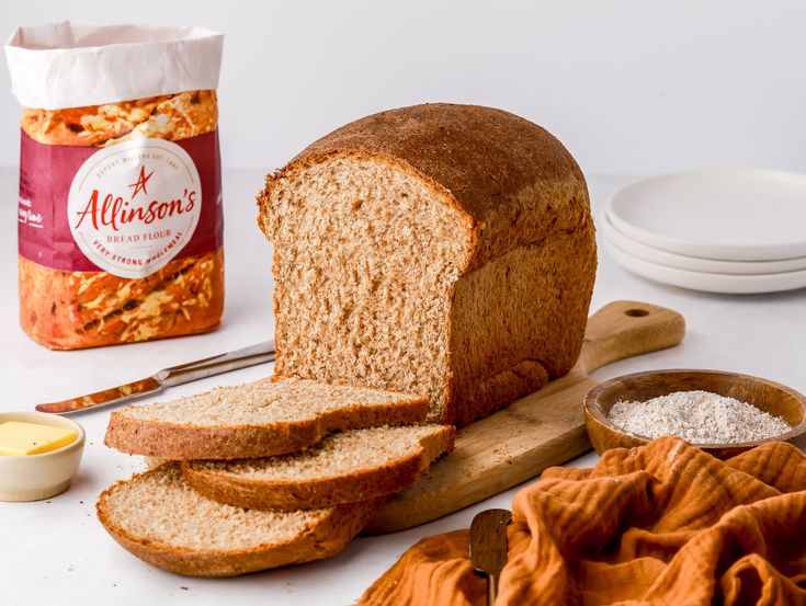 a loaf of bread sitting on top of a wooden cutting board next to other ingredients