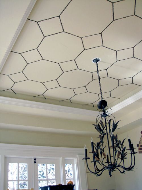 a chandelier hanging from the ceiling in a room with white walls and windows