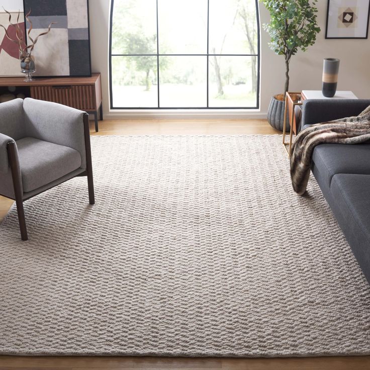 a living room with two chairs and a rug