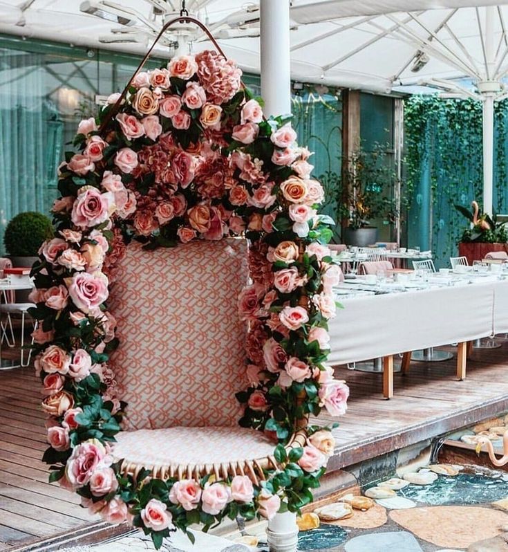 an elaborately decorated chair sits in front of a long table with tables and chairs