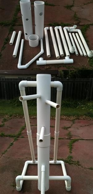 a white pipe holder with two pipes attached to it's sides on the ground