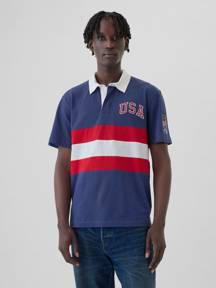 Soft cotton rugby polo shirt.  Polo collar, button placket.  Short sleeves.  Team USA graphics at chest and sleeve.  * Fit: Classic.  A straight & easy fit.  Hits at the hip.  Models are 6′1″–6′2��″ 185 cm–188 cm) with a 31″ 79 cm) waist & 32–33″ 81 cm–84 cm) inseam & are wearing Gap Rugby Polo, Team Usa, Polo Collar, Button Placket, Rugby, White Stripe, Polo Ralph Lauren, Polo Shirt, Short Sleeves