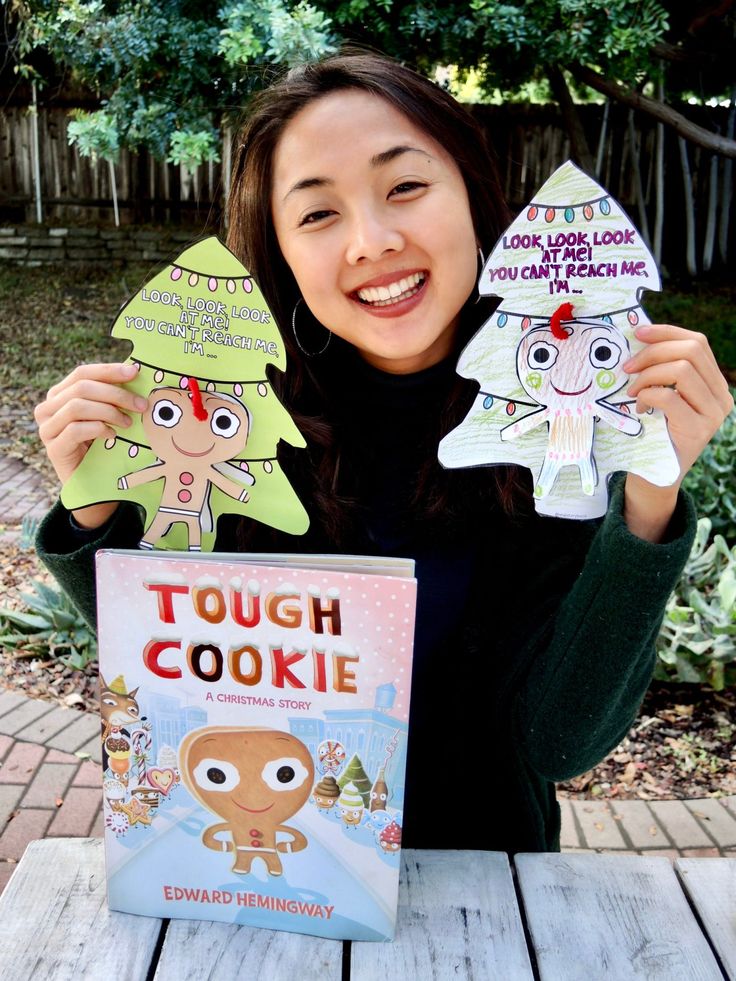 a woman is holding up two paper cut outs that say tough cookie and gingerbread