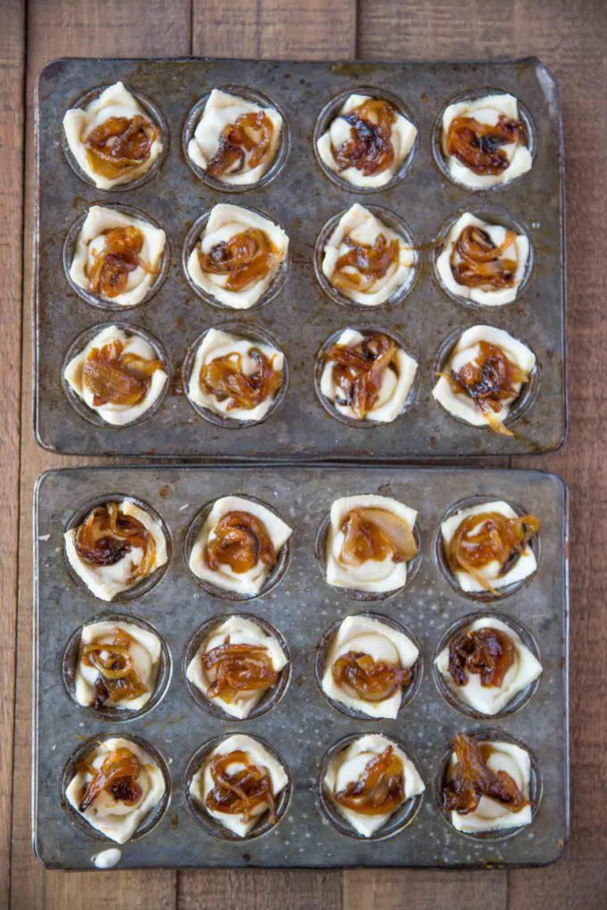 two muffin tins filled with mini pretzels on top of a wooden table