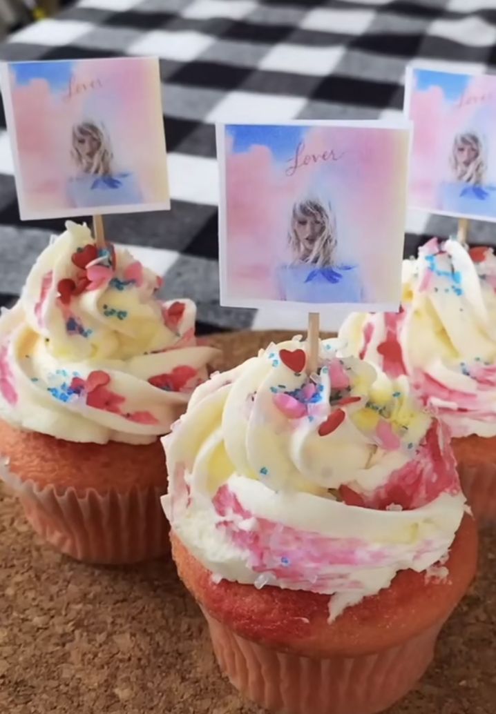 some cupcakes with white frosting and sprinkles on top are sitting on a table