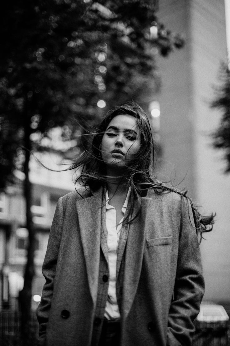 a woman with long hair standing in the street