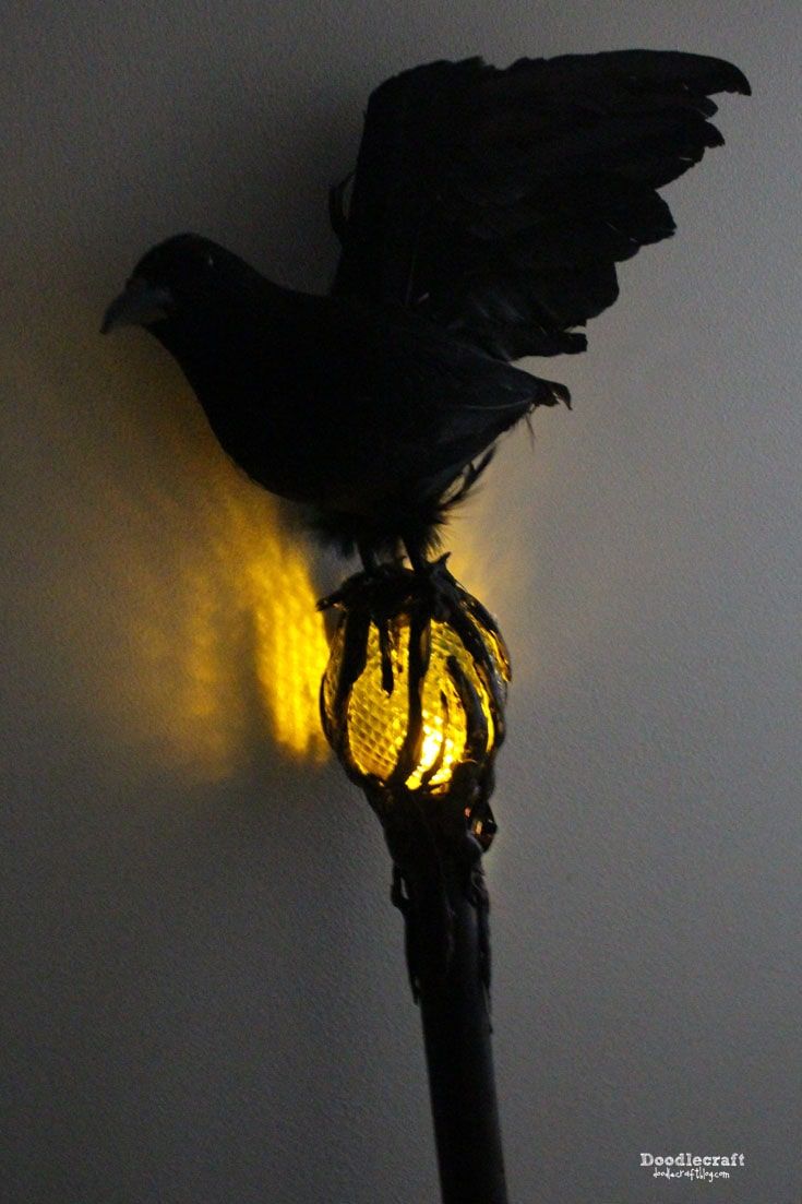 a black bird sitting on top of a yellow light