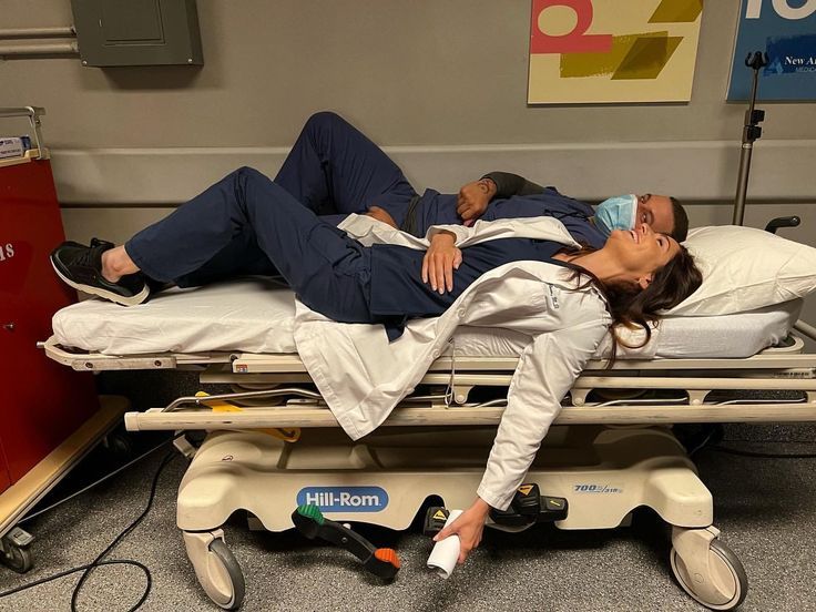 a man and woman laying on a hospital bed