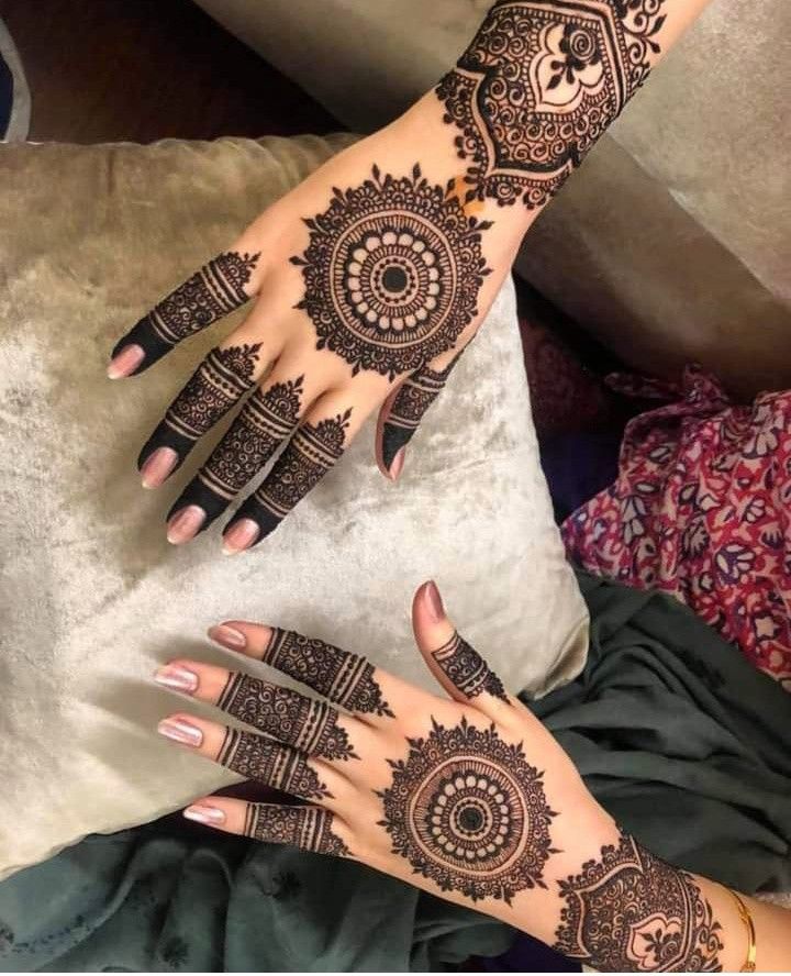 two hands with henna tattoos on them