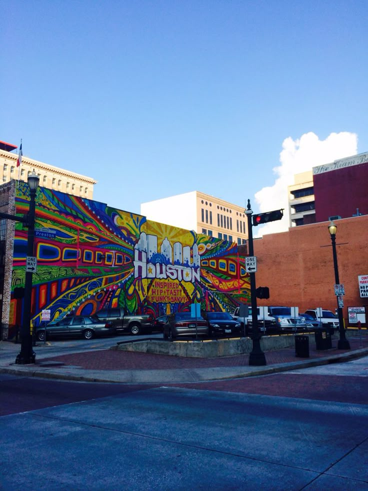 a large mural on the side of a building near a street light and traffic lights