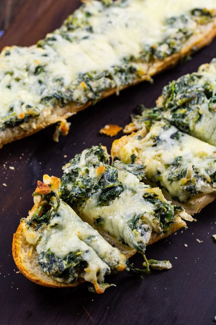 two pieces of bread with cheese and spinach on it