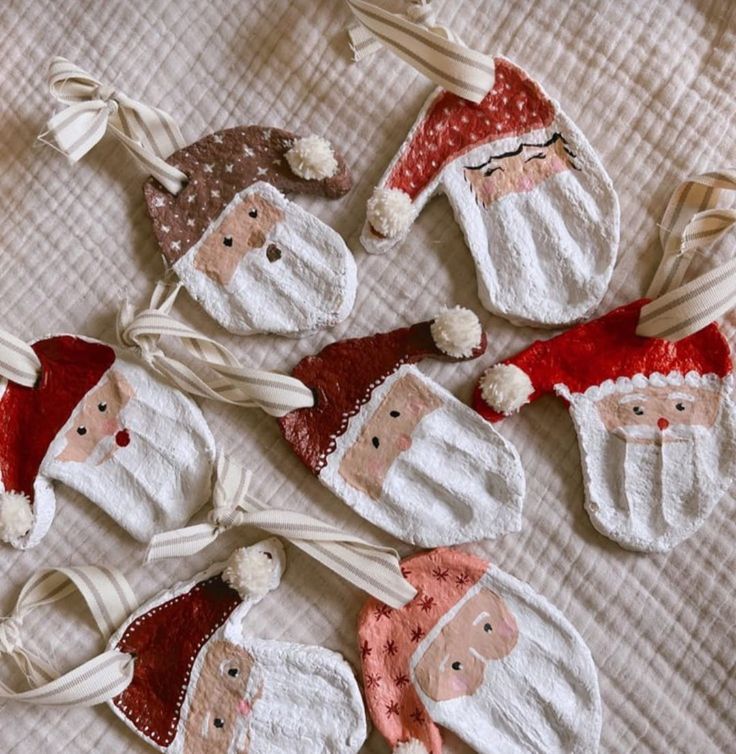 six handmade santa clause ornaments on a bed