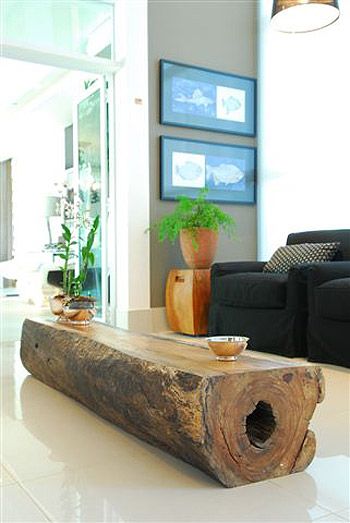 a living room filled with furniture and a large wooden log on top of a white floor