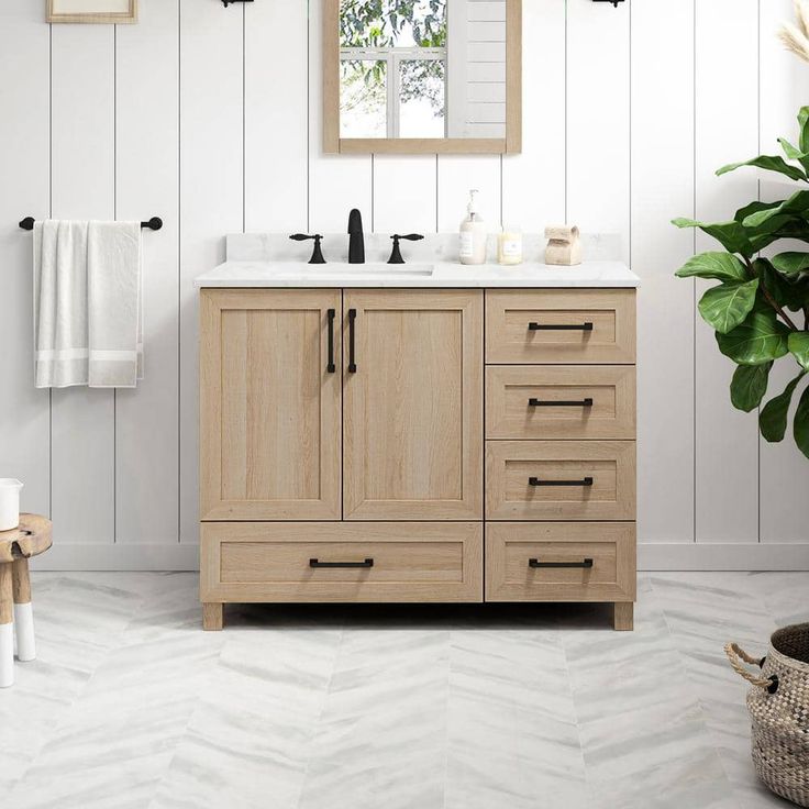 a bathroom with white walls and wooden cabinets