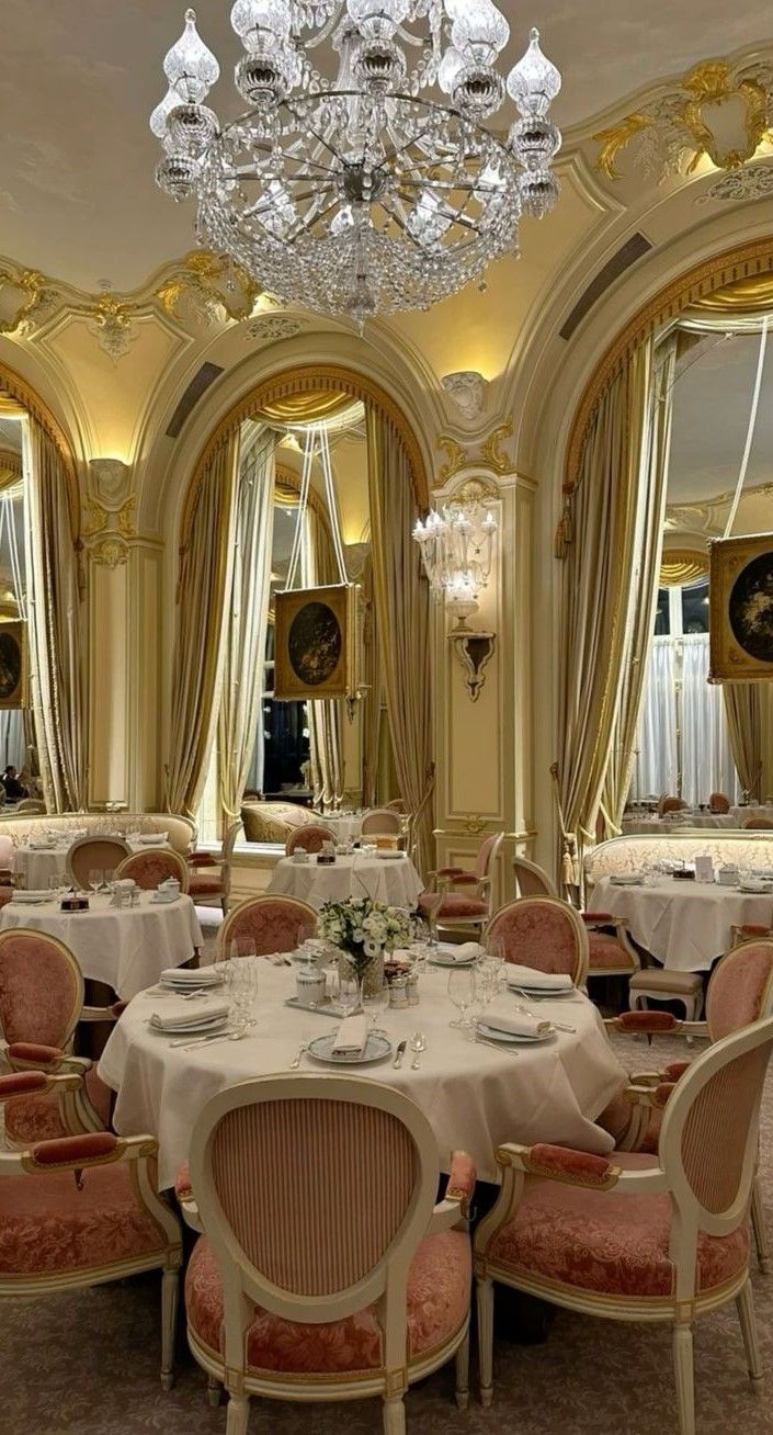 a fancy dining room with chandelier and round tables