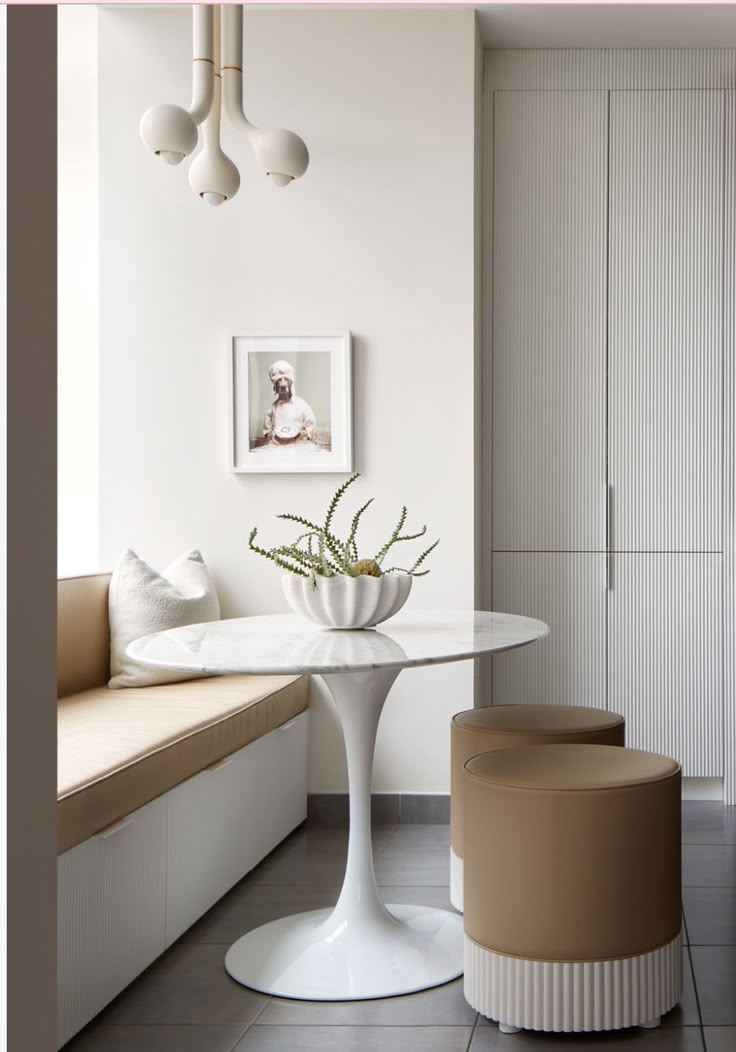 a white table and two stools in a room