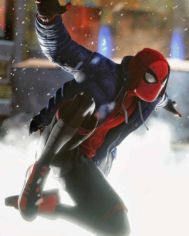 a man in a spider - man suit skates down a snowy street with his arms outstretched