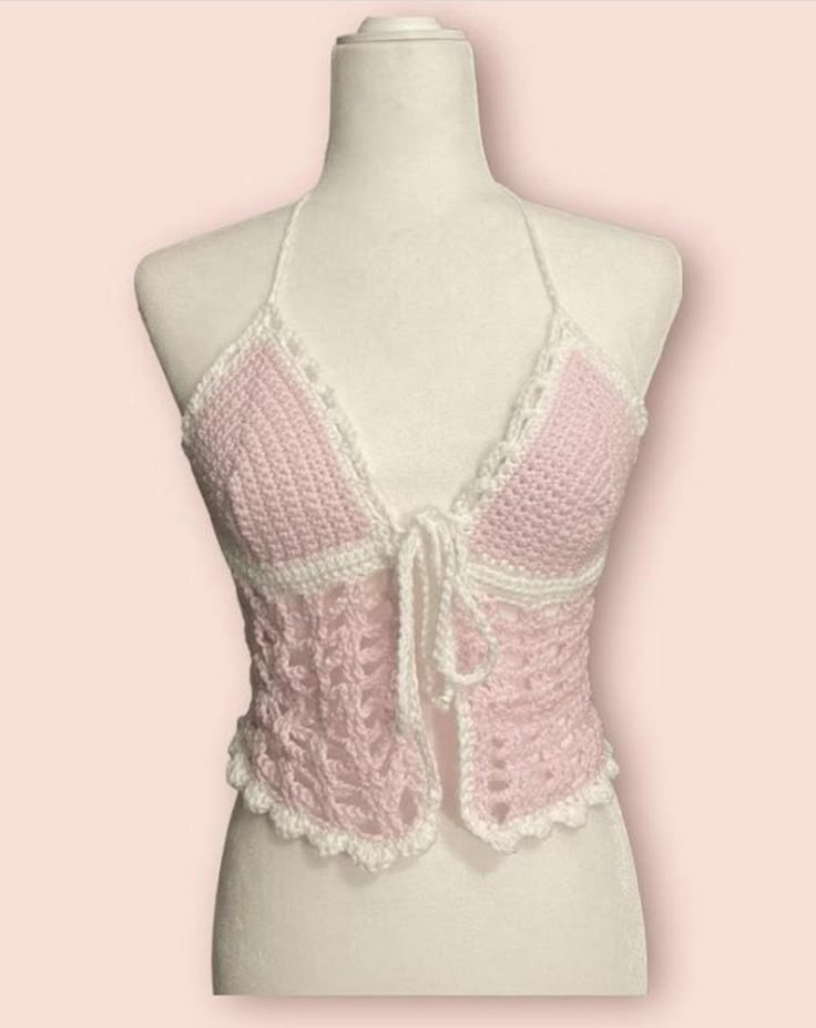 a white mannequin wearing a pink and white lacy bra with crochet