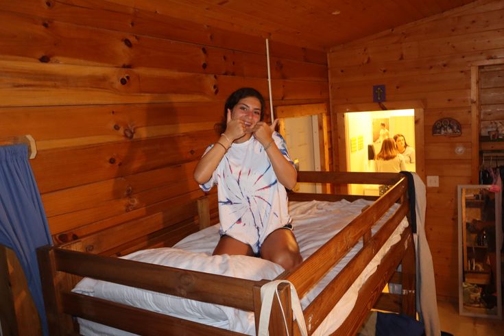 a woman sitting on top of a bed in a cabin