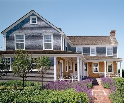 a house that is in the middle of some flowers