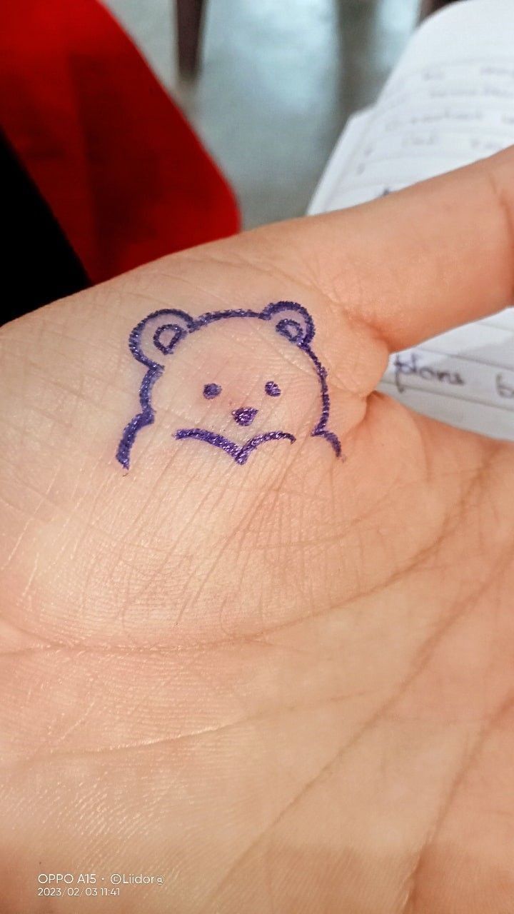 a person's hand with a small bear drawn on it