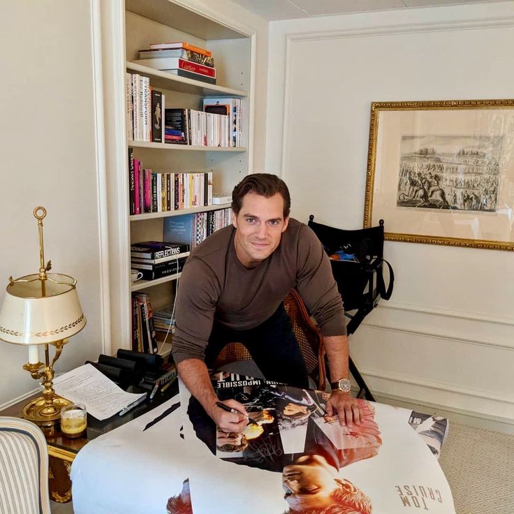 a man sitting at a table with books on it