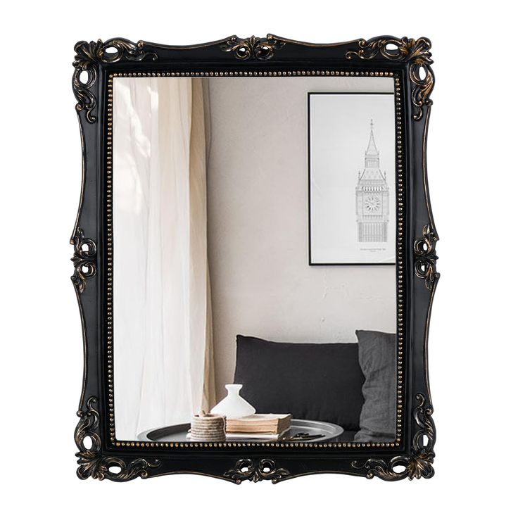 a black framed mirror sitting on top of a table