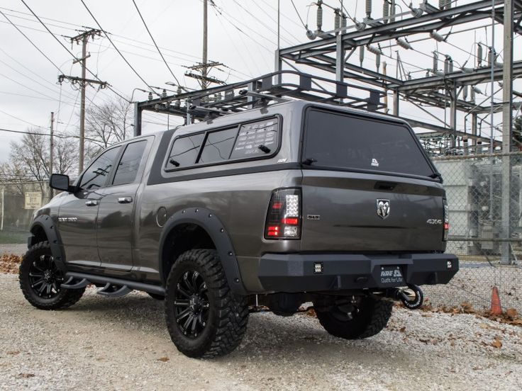 a large gray truck parked on top of a gravel road