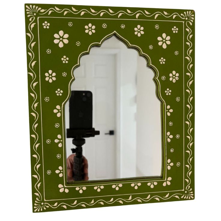 a green and white mirror with flowers on it