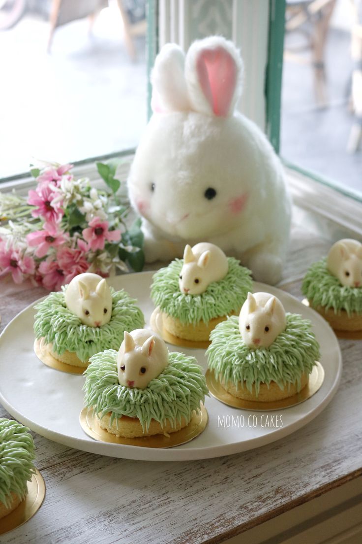 there are some cookies with green frosting on the table next to a stuffed animal