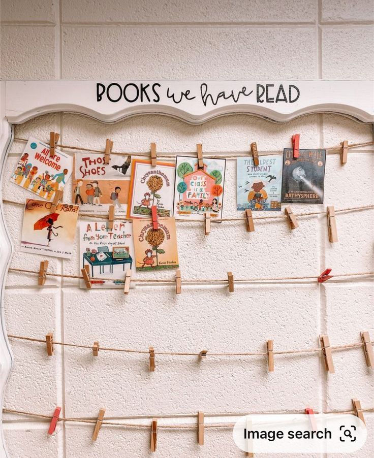 a bulletin board with clothes pins attached to it and some pictures on the pegs