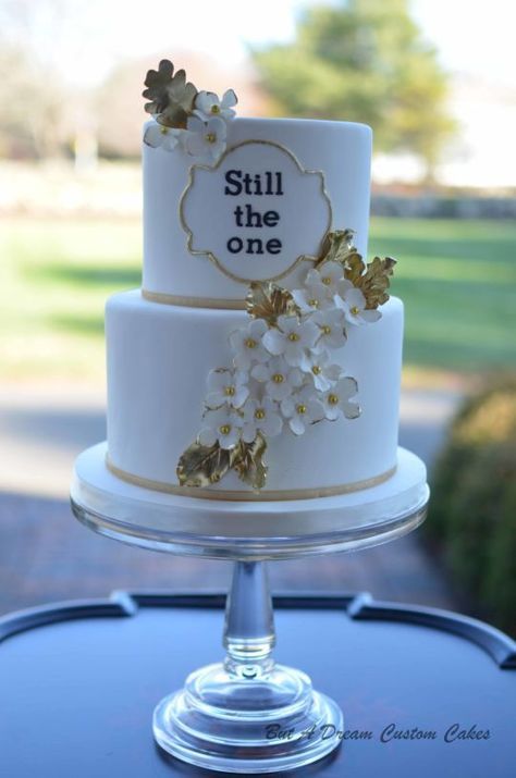 a white and gold wedding cake sitting on top of a table