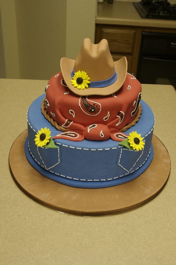 a cowboy hat on top of a blue and red cake with sunflowers in the center