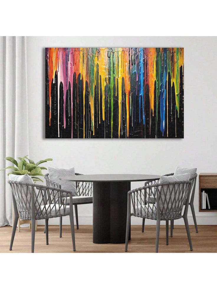 a dining room table with chairs and a painting on the wall above it that has dripping paint