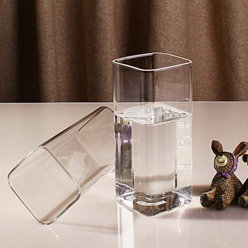 a clear glass filled with water next to a small figurine on a table