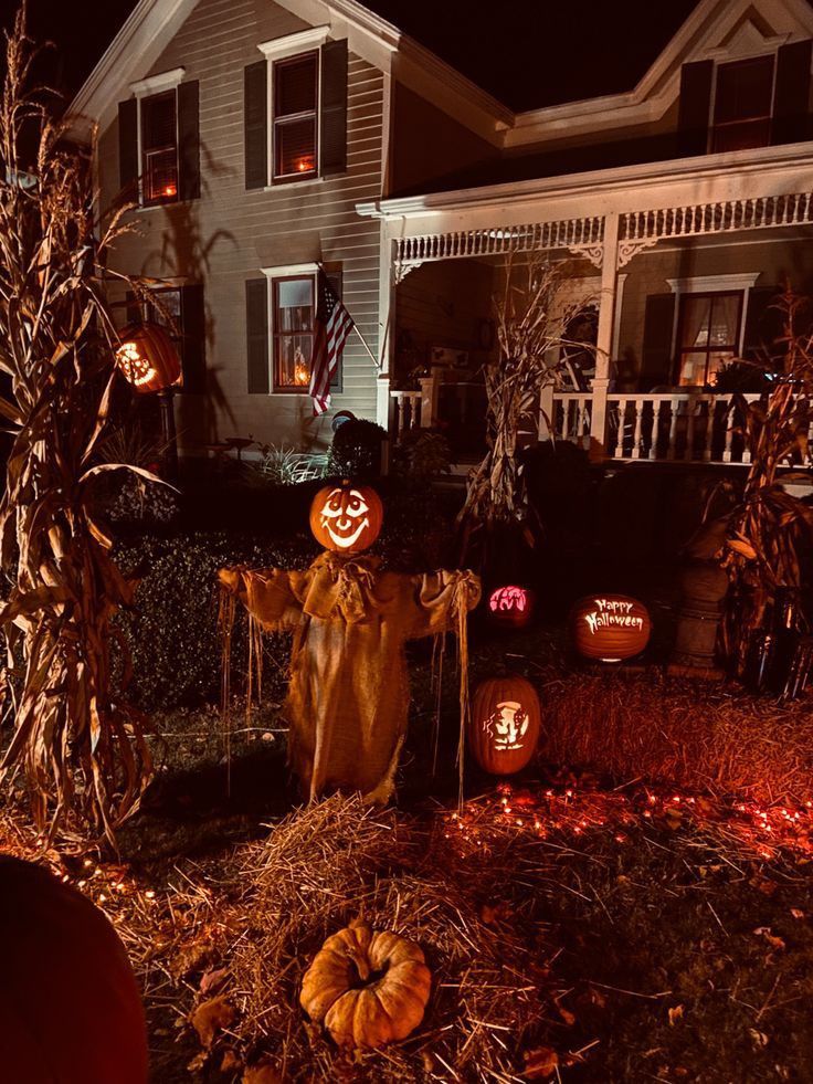 halloween decorations in front of a house at night